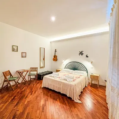 a bedroom with a bed and a table and chairs at B&B Il Mare di Terrasini in Terrasini