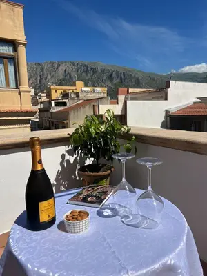a table with a bottle of wine and two glasses at B&B Il Mare di Terrasini in Terrasini