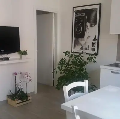 a room with a table and a plant and a picture on the wall at Appartamento Cantieri-Porto,Palermo in Palermo