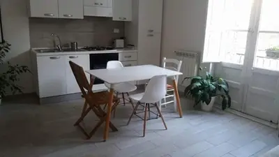 a kitchen with a white table and chairs in a room at Appartamento Cantieri-Porto,Palermo in Palermo