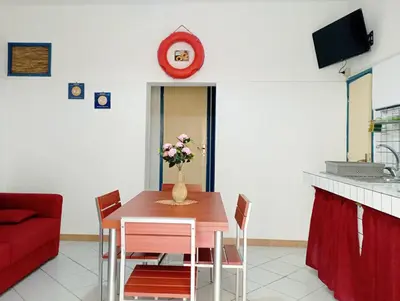 a dining room table with a vase of flowers on it at Don Vito's Apartments in Castellammare del Golfo