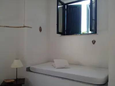 a bed in a room with a mirror and a window at Casa Mamma Bruna in San Vito lo Capo