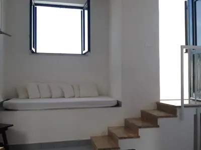 a white room with stairs with a window at Casa Mamma Bruna in San Vito lo Capo