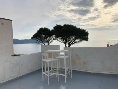 two white stools sitting on a balcony with a tree at Casa Mamma Bruna in San Vito lo Capo