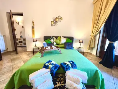 a bedroom with a green bed with towels on it at Villa Ólea Resort in Carini