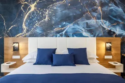 a bedroom with a bed with blue pillows at Julia's Boutique Rooms in Palermo