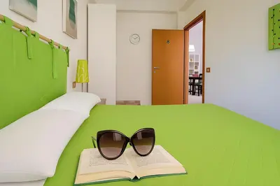 a pair of glasses sitting on a book on a bed at Green House con piscina privata 7 posti in Macari