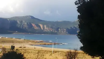 a view of a body of water with a mountain at Green House con piscina privata 7 posti in Macari