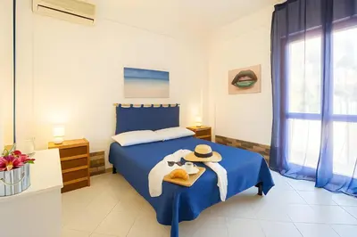 a bedroom with a blue bed with a hat on it at Green House con piscina privata 7 posti in Macari
