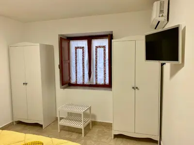 a room with white cabinets and a flat screen tv at La mia Casetta al Politeama in Palermo