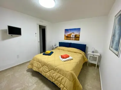 a bedroom with a bed with a yellow comforter at La mia Casetta al Politeama in Palermo