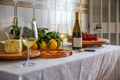 a table with two glasses of wine and cheese at Villa Stella in Alcamo