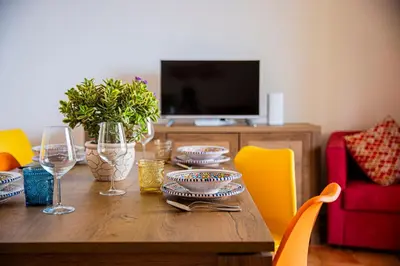 a wooden table with plates and wine glasses on it at Villa Stella in Alcamo