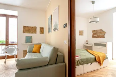 a bedroom with a bed and a couch and a chair at Casa Dolce Vita by Wonderful Italy in Palermo