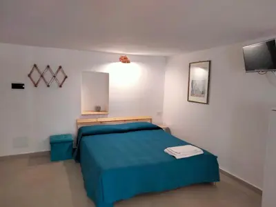 a bedroom with a blue bed and a tv at Casa Nadir in Palermo