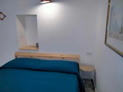 a bedroom with a bed with a blue blanket at Casa Nadir in Palermo