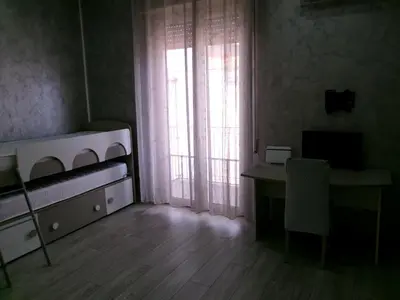 a kitchen with white cabinets and a black counter top at Antadia Terminal Bus in Palermo