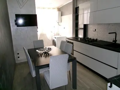 a kitchen with white cabinets and a black counter top at Antadia Terminal Bus in Palermo