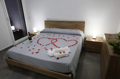 a bed with a heart made out of red roses at Trabia Casa Bianca B in Mandra Capreria
