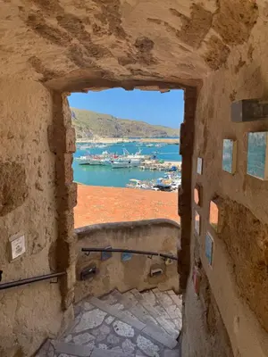 a view of a harbor through an arch in a building at DA REMO apartment in Castellammare del Golfo