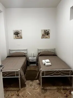 two beds in a room with white walls at Casa Sulia in Terrasini