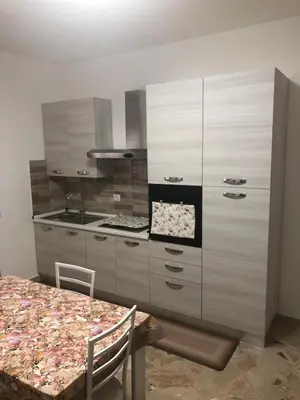 a kitchen with a table and a large cabinet at Casa Sulia in Terrasini