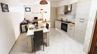 a kitchen and living room with a table and a dining room at Casa Amodei 1 a pochi passi dal mare in San Vito lo Capo
