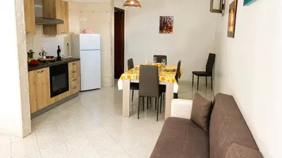 a kitchen and dining room with a table and a couch at Casa Amodei 1 a pochi passi dal mare in San Vito lo Capo