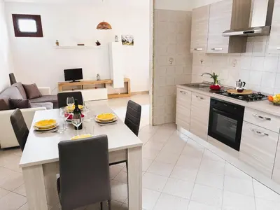 a kitchen and living room with a table and chairs at Casa Amodei 1 a pochi passi dal mare in San Vito lo Capo