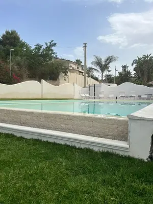 a swimming pool with blue water in a resort at Le Onde della Sicciara in Balestrate