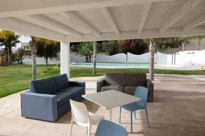 a patio with two couches and a table and chairs at Le Onde della Sicciara in Balestrate