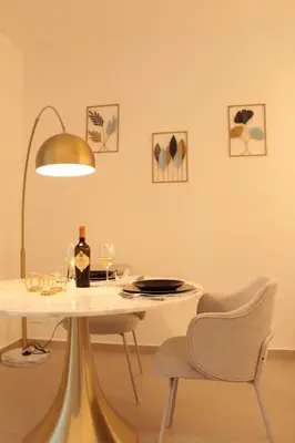 a dining room with a white table and a lamp at Le Onde della Sicciara in Balestrate