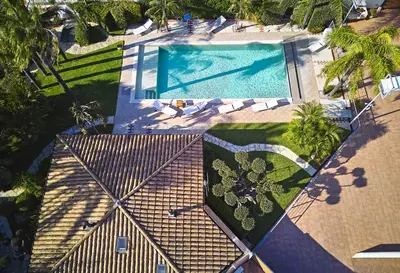 an overhead view of a swimming pool with palm trees at Villa Palme in Alcamo Marina