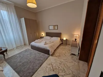 a bedroom with a large bed and a table at CapoMassimo in Palermo
