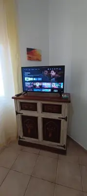 a tv sitting on top of a wooden cabinet at Villa Alba in Palermo