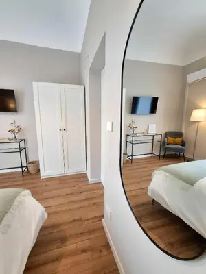 a mirror in a bedroom with a bed and a desk at MAGGESE Dimora di Charme in Palermo