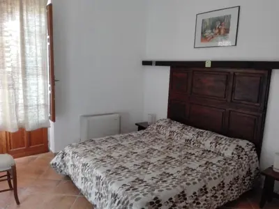 a bedroom with a bed with a wooden headboard at Casale di Riena in Lercara Friddi