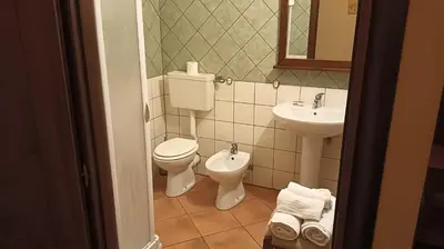 a bathroom with a toilet and a sink at Casale di Riena in Lercara Friddi