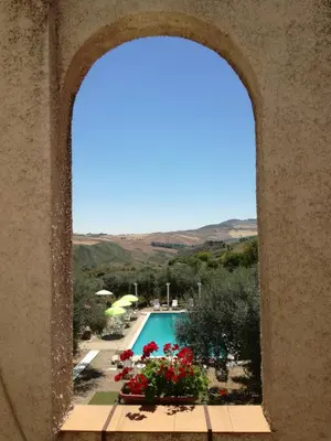 a view of a swimming pool through a window at Casale di Riena in Lercara Friddi