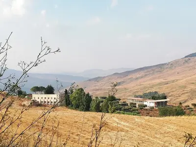 a village on a hill with houses in a field at Casale di Riena in Lercara Friddi