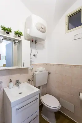 a bathroom with a white toilet and a sink at Palermo Central Holiday in Palermo