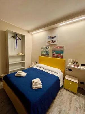 a bedroom with a blue bed with towels on it at FronteMare12 in Palermo