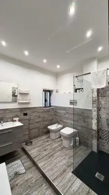 a bathroom with two sinks and a toilet and a shower at FronteMare12 in Palermo