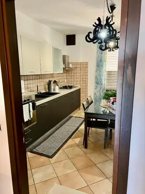 a kitchen with a table and a chandelier at Casa Yasmine in Santa Flavia