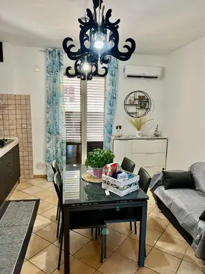 a living room with a table and a chandelier at Casa Yasmine in Santa Flavia