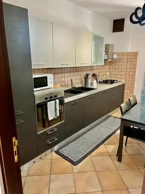 a kitchen with stainless steel appliances and a table at Casa Yasmine in Santa Flavia