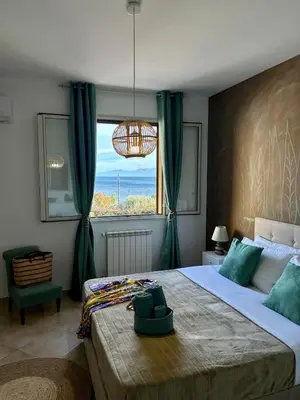 a bedroom with a large bed with a large window at Casa Yasmine in Santa Flavia
