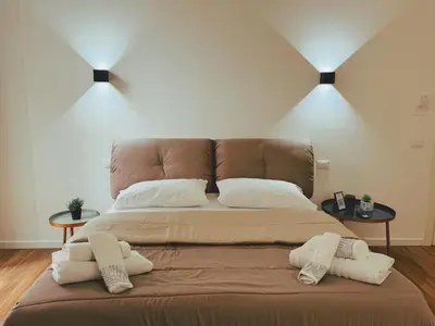 a large bed in a room with two tables at Candalù - Palermo Suite in Palermo