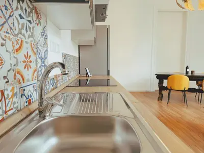 a kitchen with a stainless steel sink and a table at Candalù - Palermo Suite in Palermo