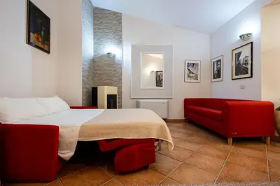 a bedroom with a bed and a red couch at Gulliver's Nest in Castellammare del Golfo